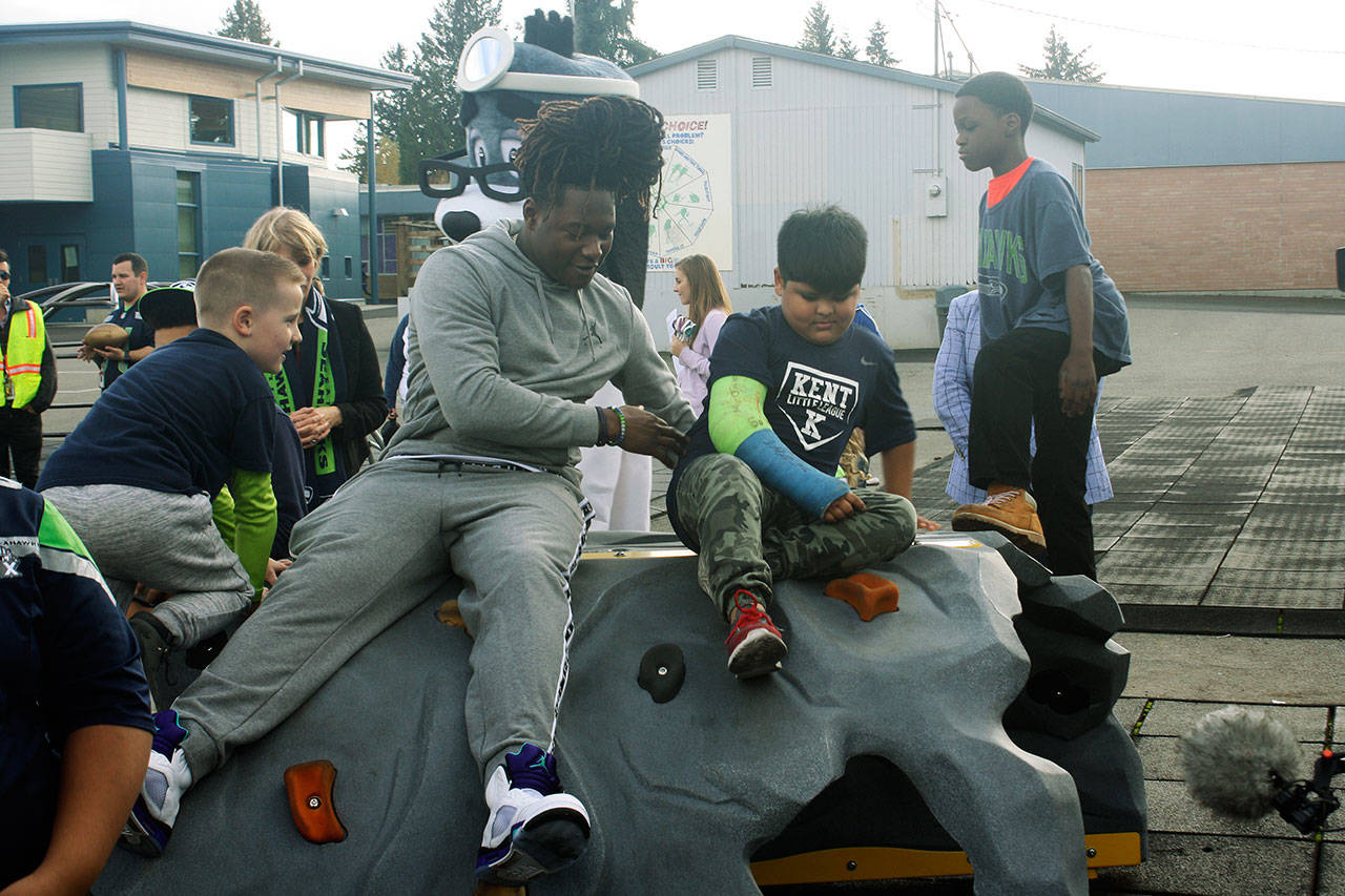 Seattle Seahawks linebacker Shaquem Griffin joins kids on a new climbing rock Tuesday at Park Orchard Elementary School in Kent. STEVE HUNTER, Kent Reporter