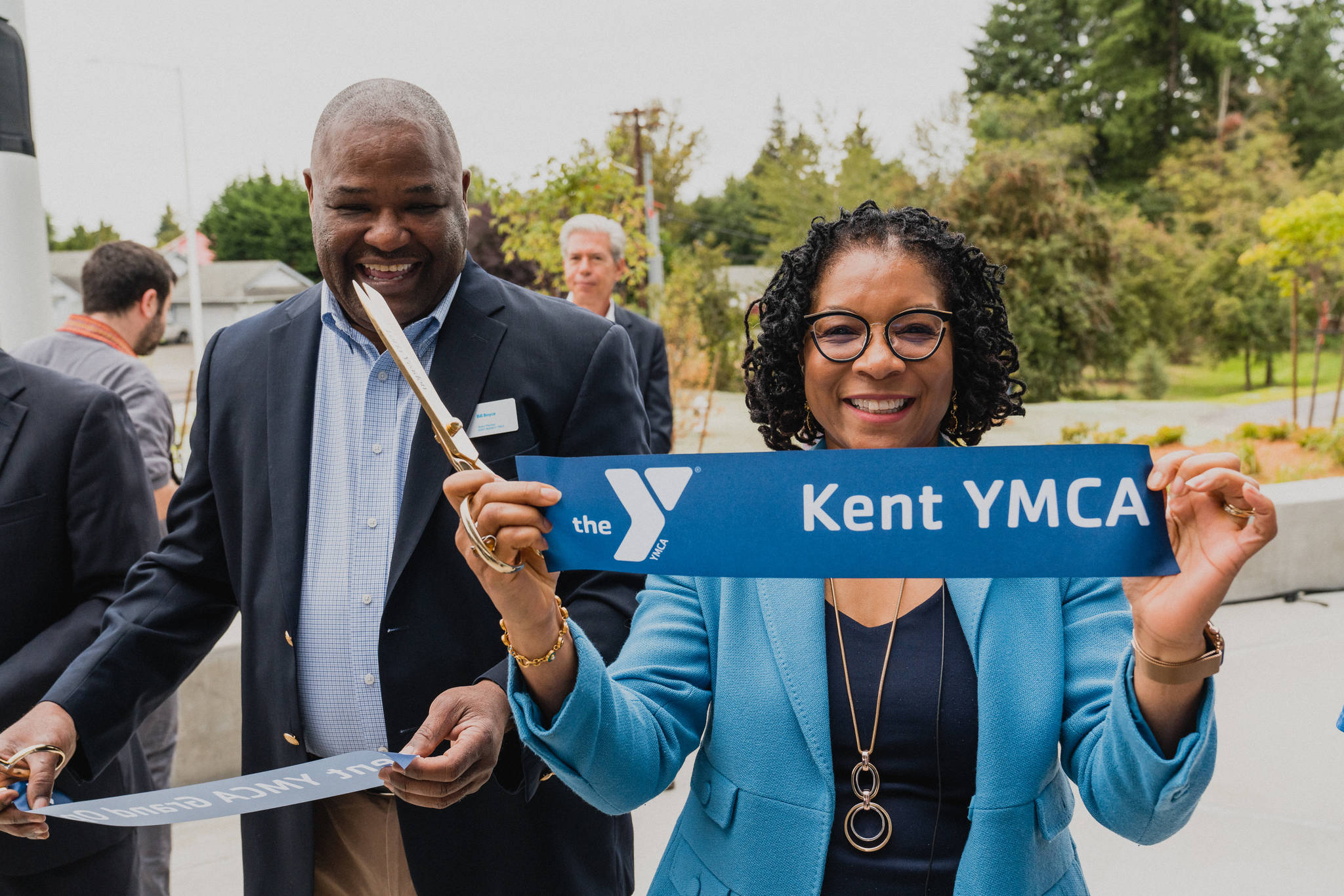 Loria Yeadon, CEO and president of the YMCA of Greater Seattle, shows a piece of the freshly cut ribbon during the grand-opening celebration of the new Kent Y on Saturday. Joining Yeadon at the ceremony is Bill Boyce, Kent City Council president, left. After more than 10 years of planning, work and coordination from community partnerships, the Kent Y officially opened to the public. COURTESY PHOTO, Brandon Patoc (patoc.co)