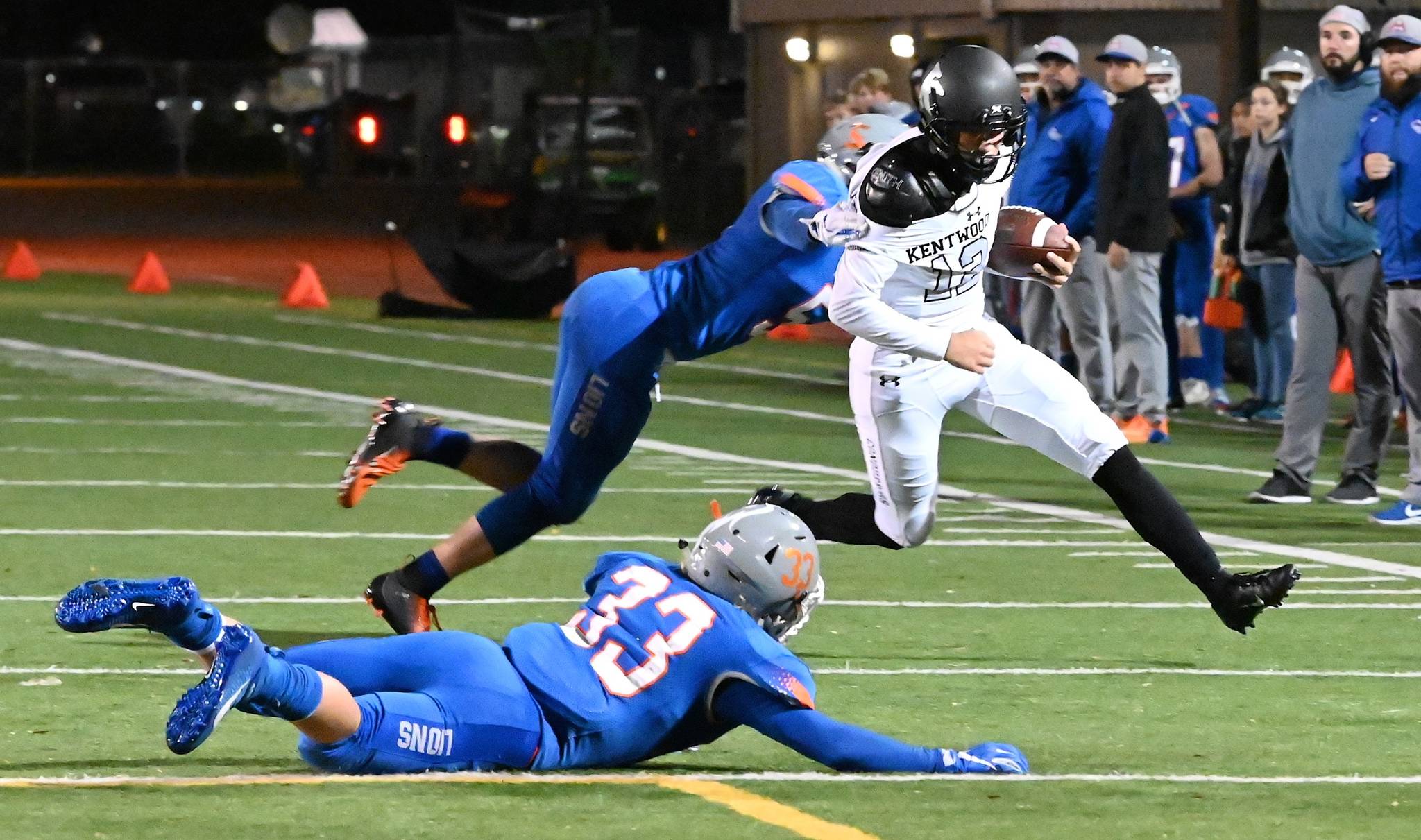 Kentwood quarterback Jackson Proctor dashes goal-ward as Auburn Mountainview’s Teagin Child and Cooper White (33) pursue during NPSL first-half play Friday night. RACHEL CIAMPI, Kent Reporter