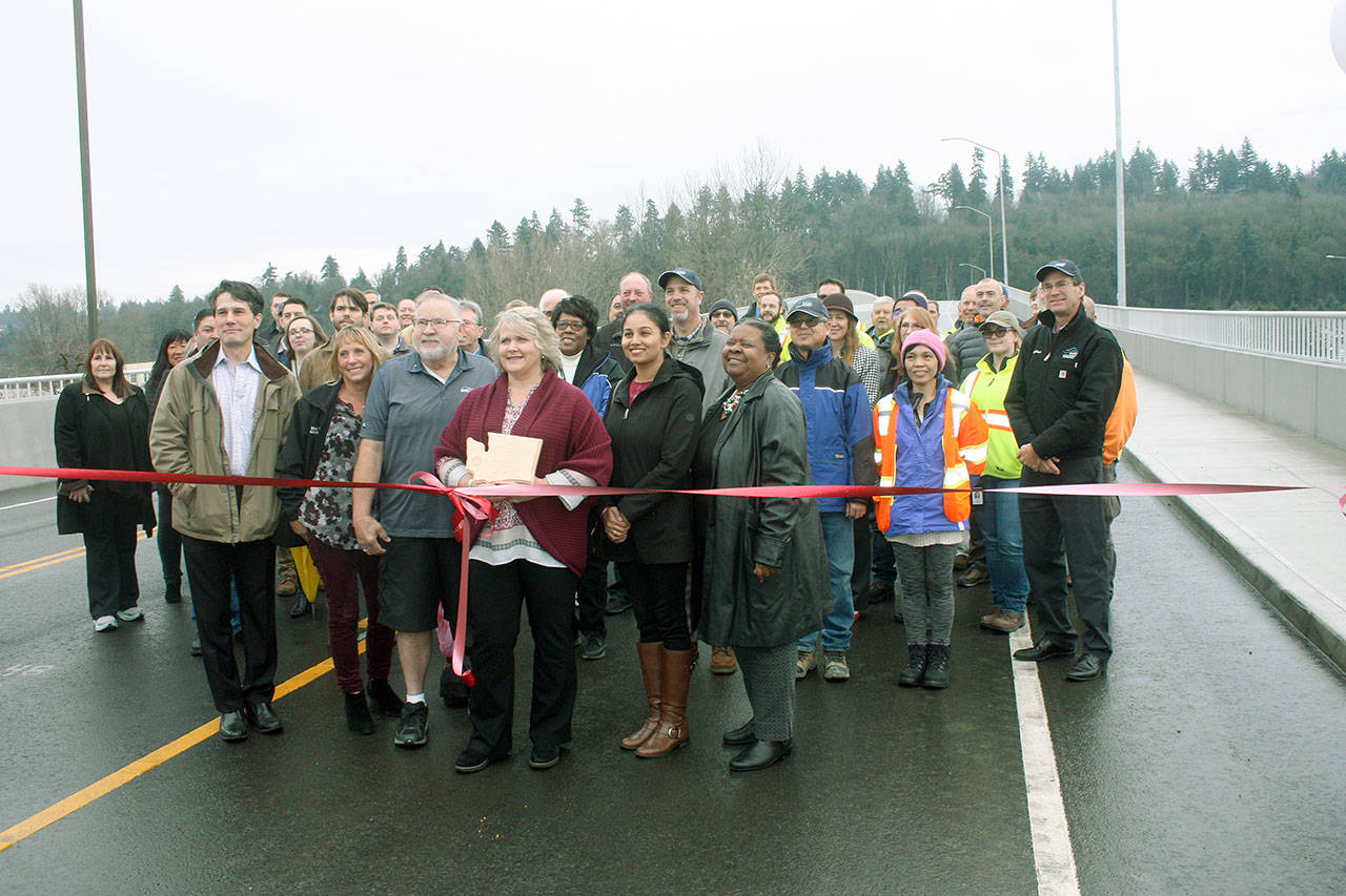 Major Dana Ralph, city council members, city department leaders and project partners gather Dec. 11 for a ribbon-cutting ceremony in front of the new South 224th Street bridge. MARK KLAAS, Kent Reporter