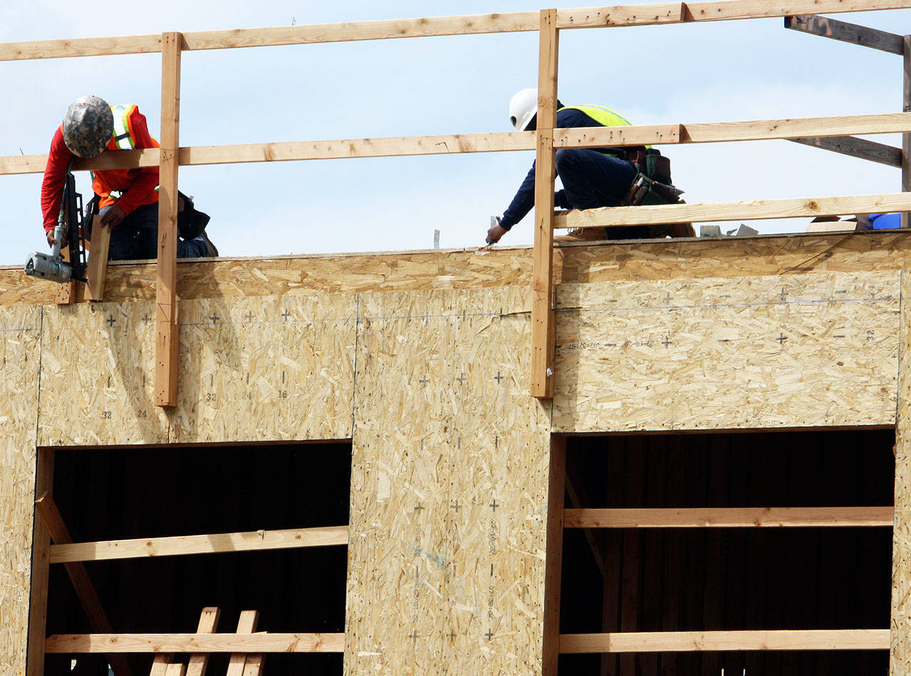 Crews work on the back row of units at the Midtown 64 Apartments along West Meeker Street in Kent. STEVE HUNTER, Kent Reporter