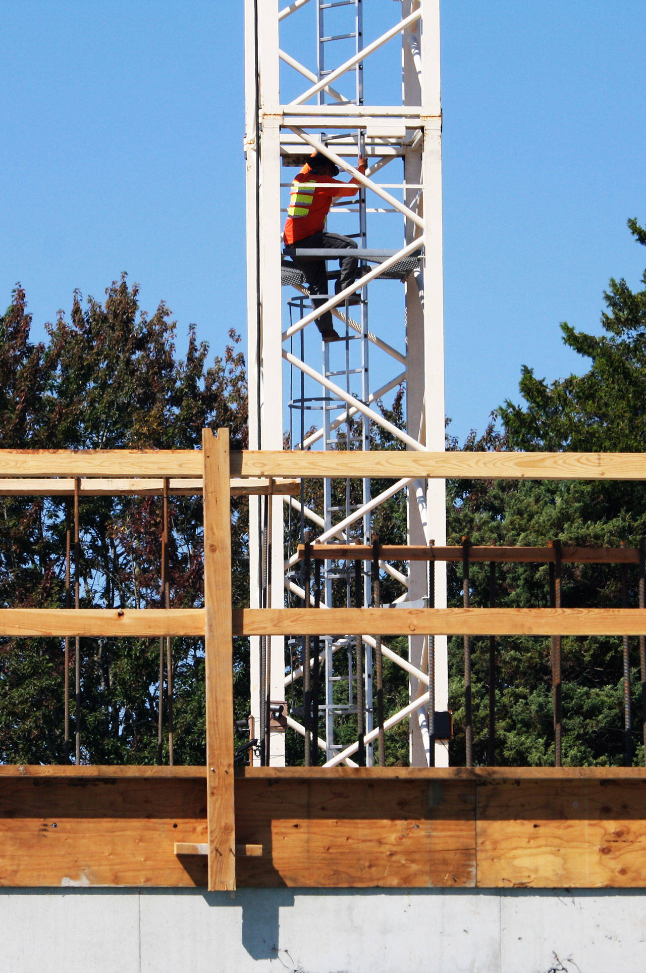 A construction crew member on Tuesday, Aug. 25, scrambles down the crane in place to build the Madison Plaza Apartments in Kent, 102 Madison Ave. N. STEVE HUNTER, Kent Reporter