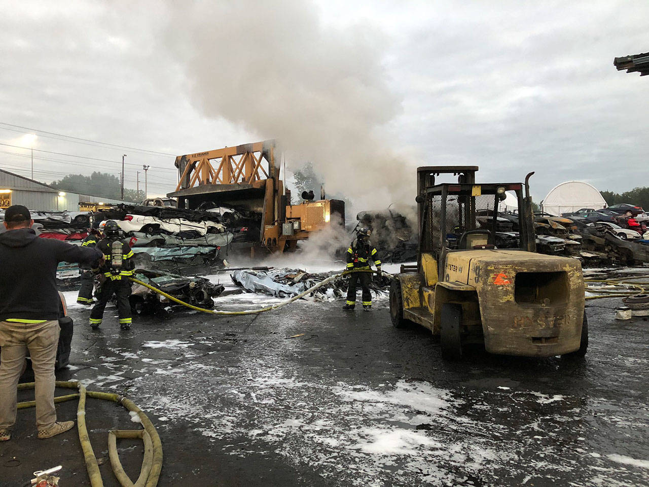 Firefighters methodically remove vehicles from the pile to complete extinguishment early Tuesday, Sept. 1 at a wrecking yard in the 26100 block of 78th Avenue South in Kent. COURTESY PHOTO, Puget Sound Fire