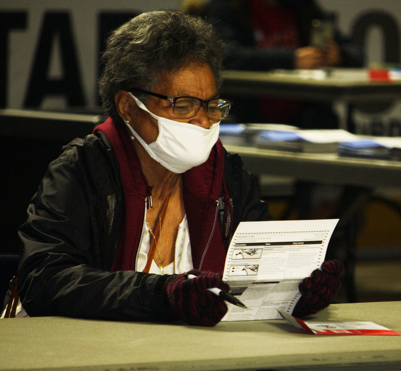 A woman closely studies her ballot at the Vote Center Tuesday, Nov. 3 inside the accesso ShoWare Center. STEVE HUNTER, Kent Reporter