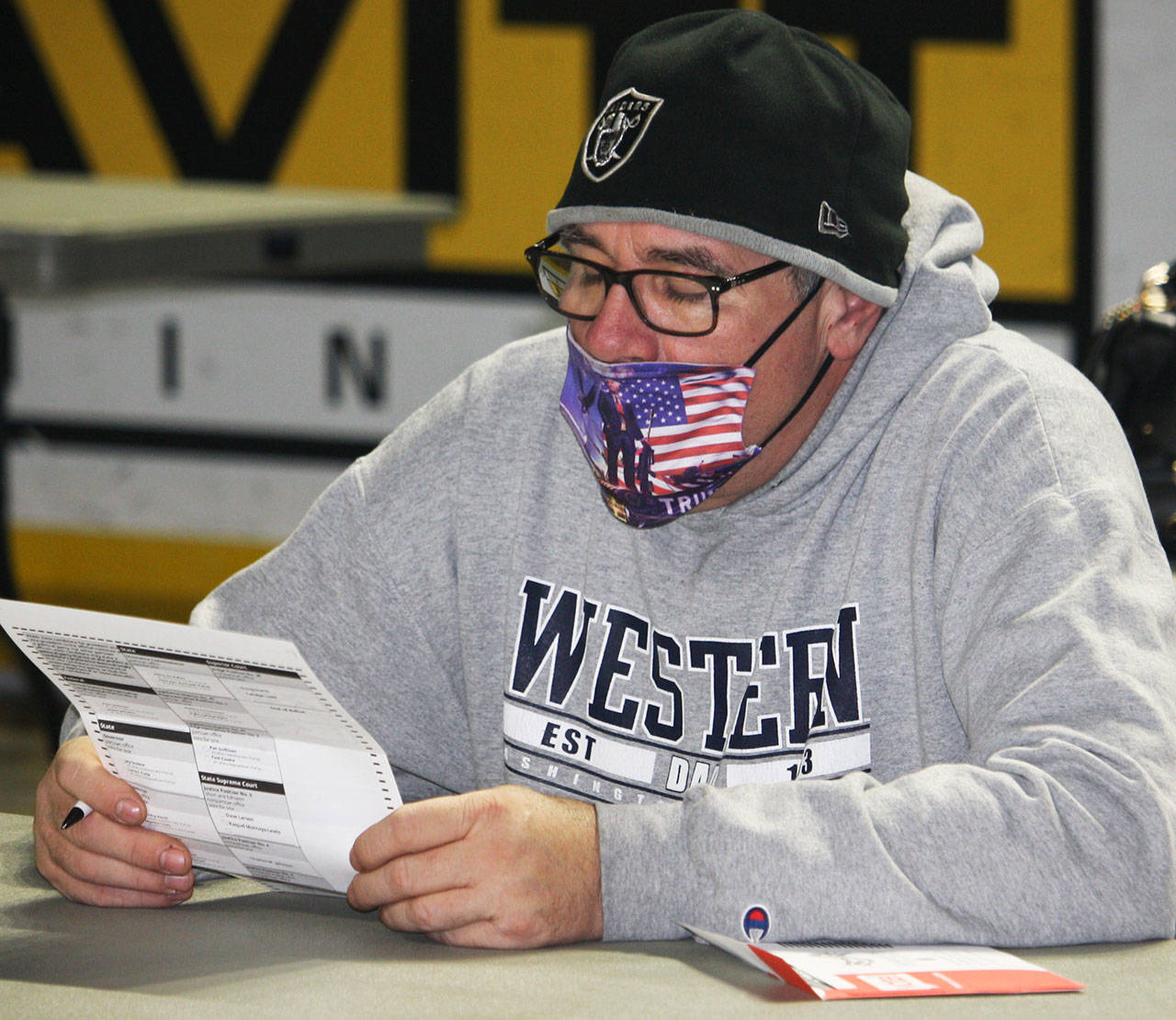 A man reads his ballot on Tuesday, Nov. 3 at the Vote Center inside the accesso ShoWare Center. STEVE HUNTER, Kent Reporter