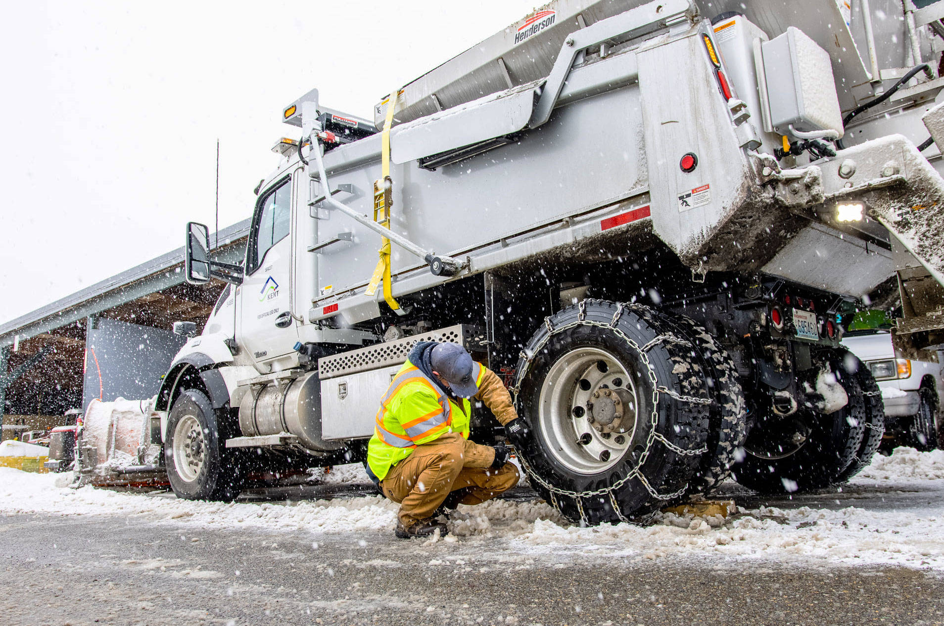 A crew member checks the chains on a snowplow. COURTESY PHOTO, City of Kent