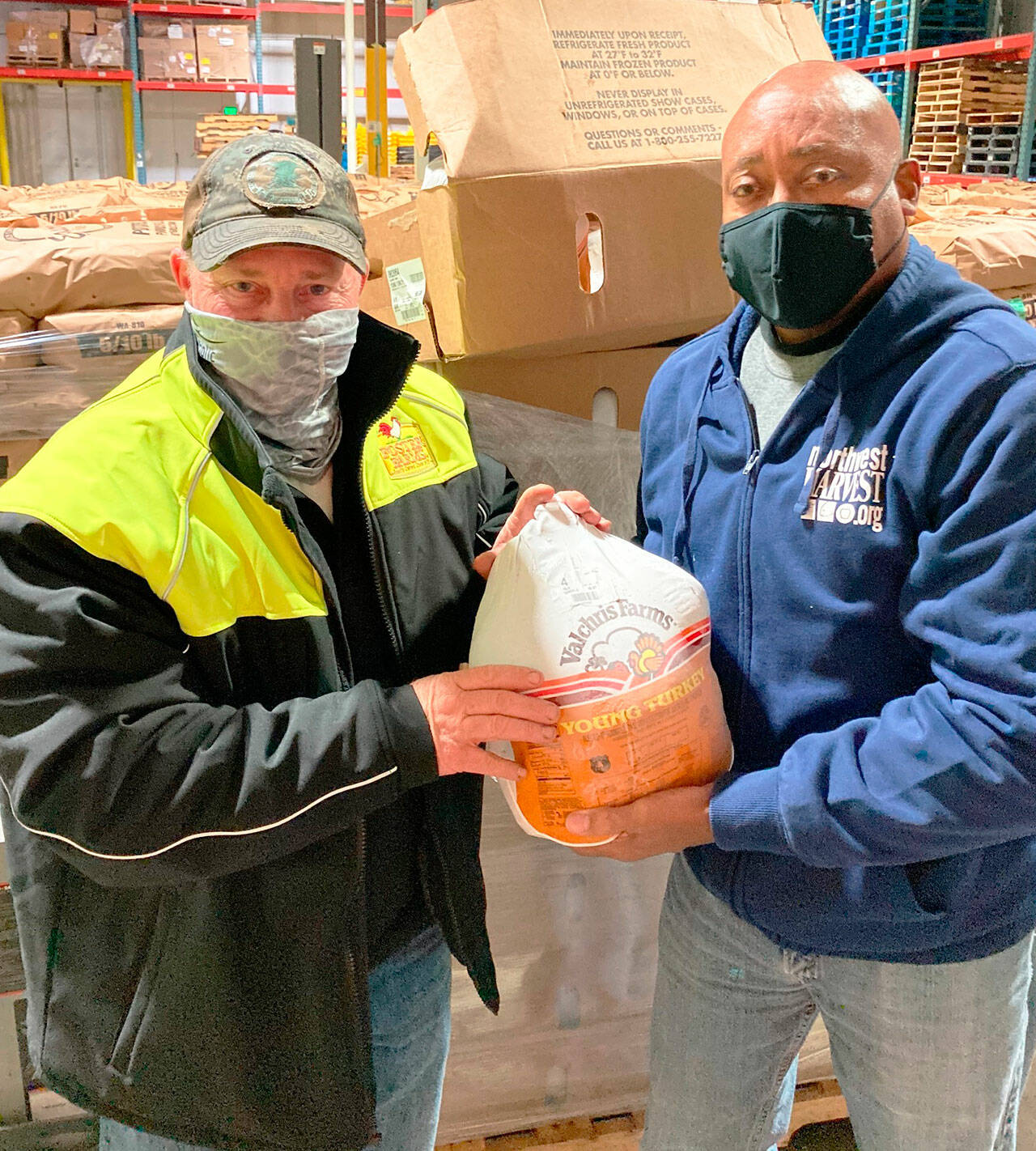 A driver presents a turkey to RIchard Jones, Northwest Harvest operations manager, on Nov. 1 in Kent. COURTESY PHOTO, Foster Farms