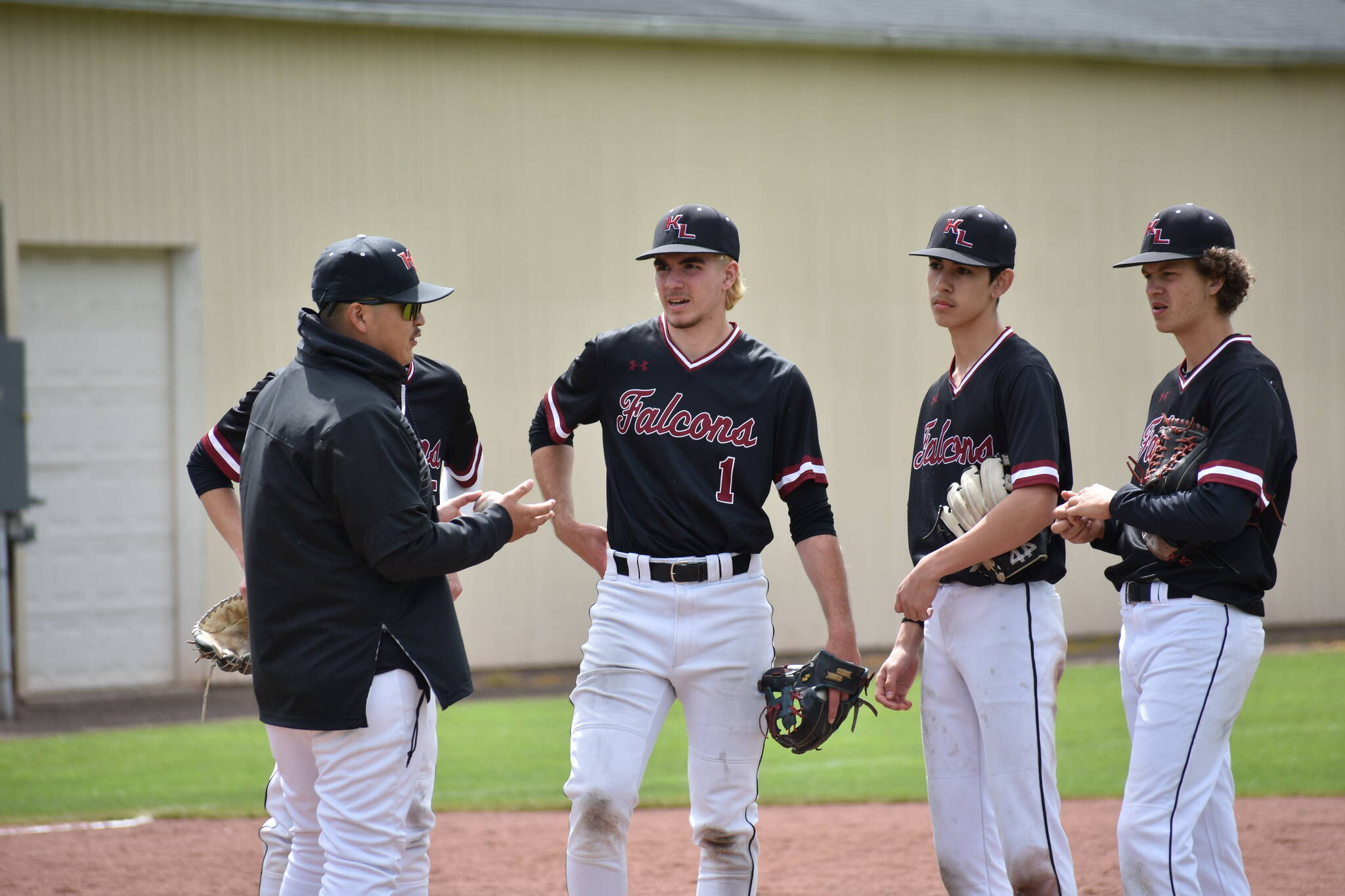 Kentlake’s infield meets during a pitching change. Ben Ray / The Reporter