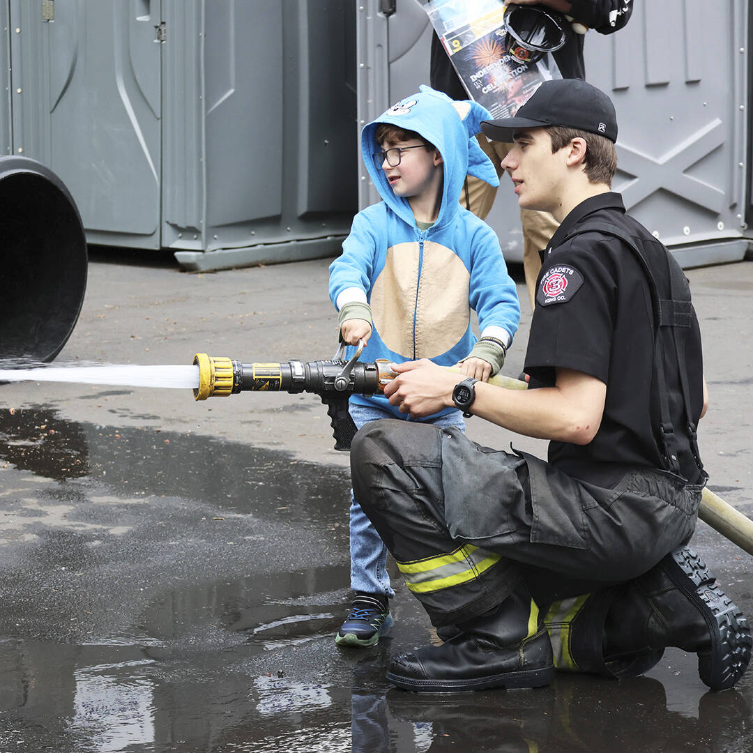 A child gets a chance to use a fire hose during Puget Sound Fire’s Teddy Bear Clinic on May 18. COURTESY PHOTO, Puget Sound Fire