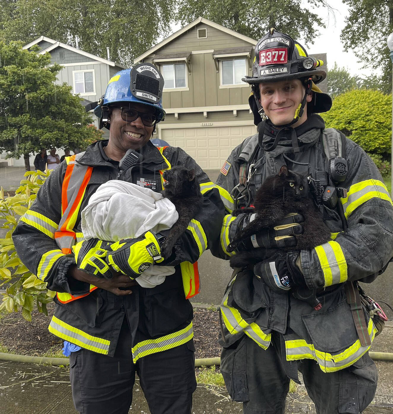 A paramedic and a firefighter hold cats rescued from a house fire June 3 in Kent in the 23400 block of 134th Court SE. COURTESY PHOTO, Puget Sound Fire