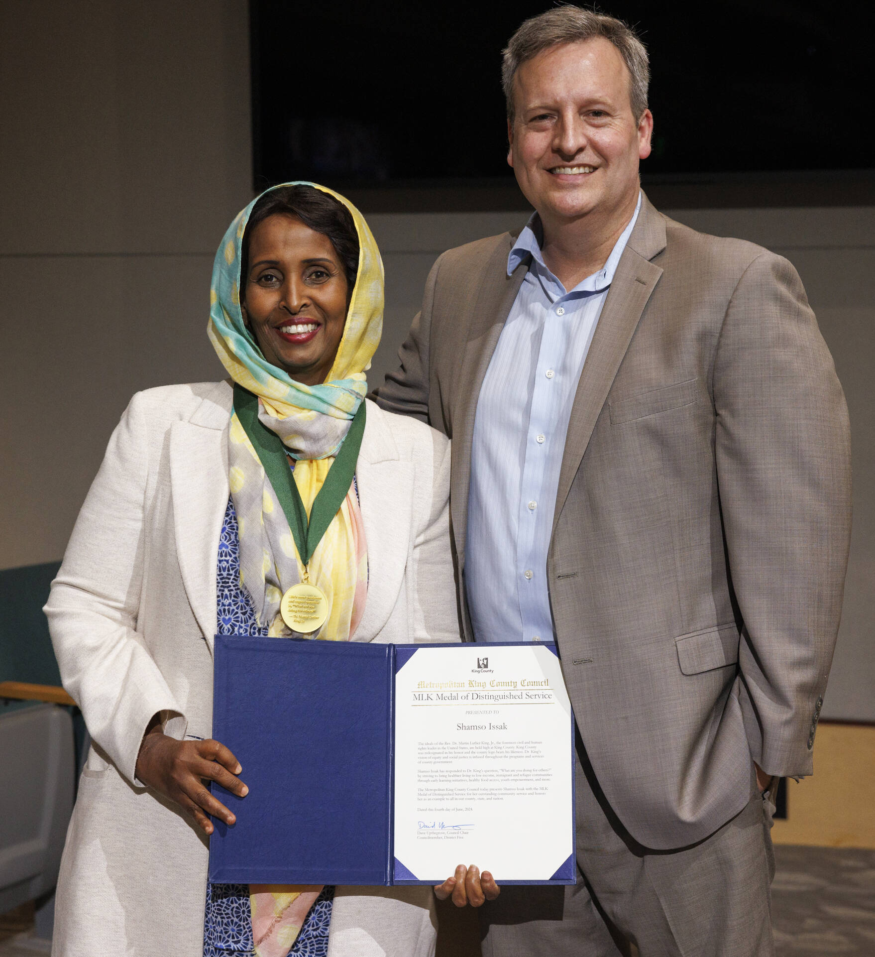 Shamso Issak, of Kent, receives King County’s Martin Luther King Jr. Distinguished Service Award from County Councilmember Dave Upthegrove June 4 at the Council chambers in Seattle. COURTESY PHOTO, King County