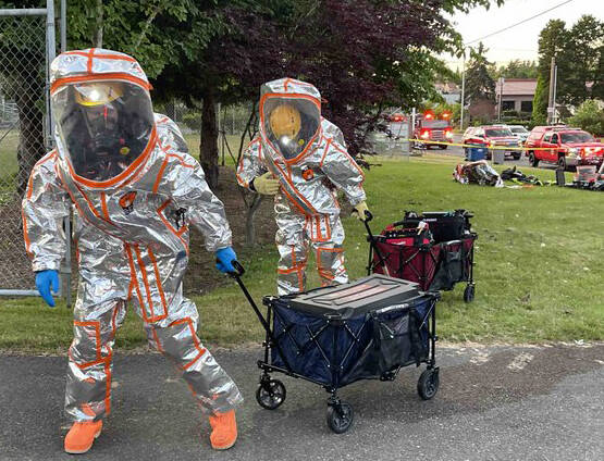 Firefighters put on special suits to enter a city of Kent building June 12 and stop a chlorine gas leak from tanks next to a city well. COURTESY PHOTO, Puget Sound Fire