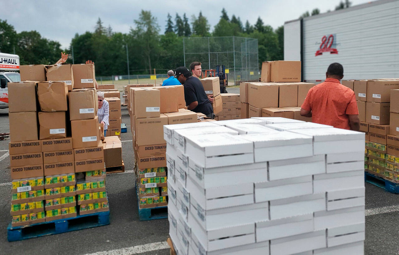 Volunteers organize more than 1,200 cases of food donated by The Church of Jesus Christ of Latter-Day Saints June 13 at King of Kings Lutheran Church in Renton. Volunteers distributed the food to three Kent organizations in addition to the church. COURTESY PHOTO