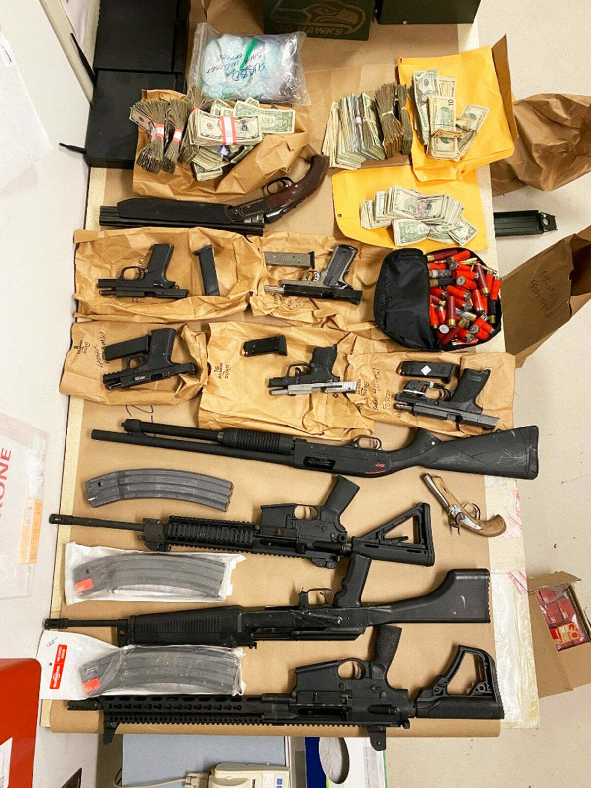 Guns and cash seized by federal law enforcement officers in 2022 as part of a drug trafficking ring bust in Washington and California that resulted in 17 indictments on drug charges. COURTESY PHOTO, FBI