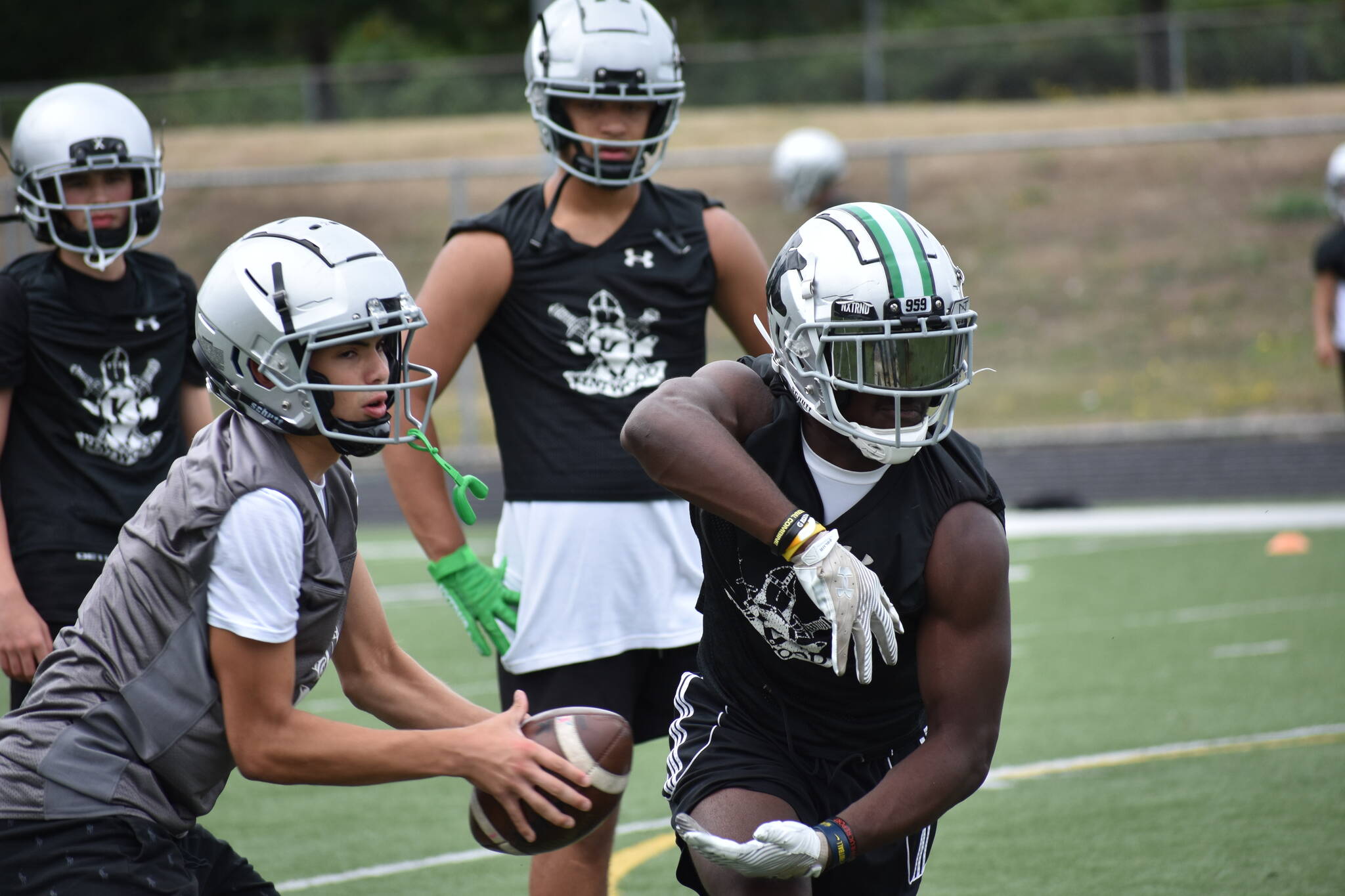 Kentwood RB Antoine Lee (right) and new quarterback Brandon Tagle (left) get some work in during practice at Kentwood. Photos by Ben Ray / The Reporter