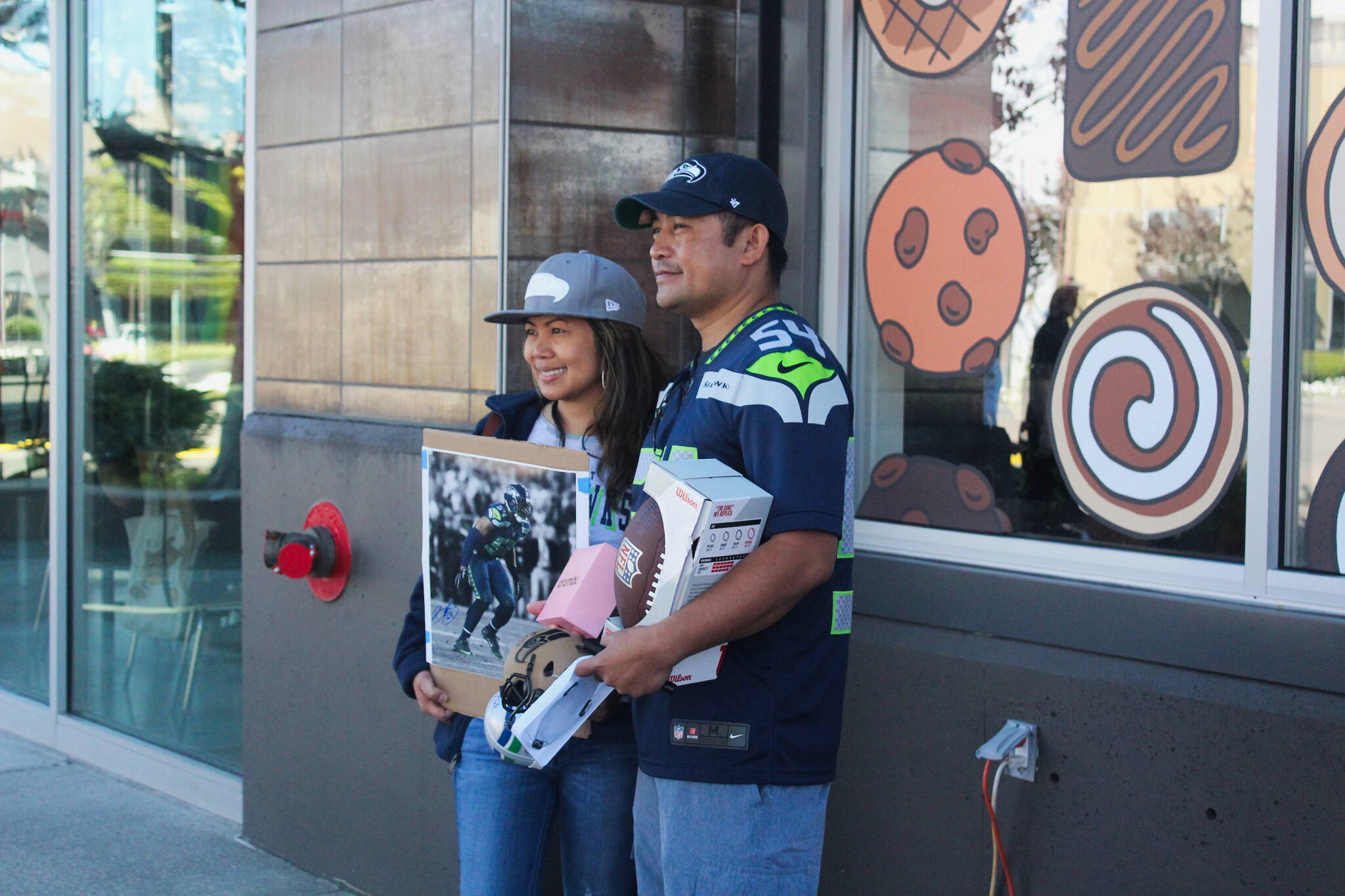 Rodina Bumanglag (left) of Renton and Reggie Tagalicod of Las Vegas arrived at 8 a.m. to meet Bobby Wagner and Richard Sherman at the grand opening of Crumble Cookies in Renton. Bumanglag said that she has been a Seahawk fan for a couple years and wanted to come out and support Wagner. Photo by Bailey Jo Josie/Sound Publishing.