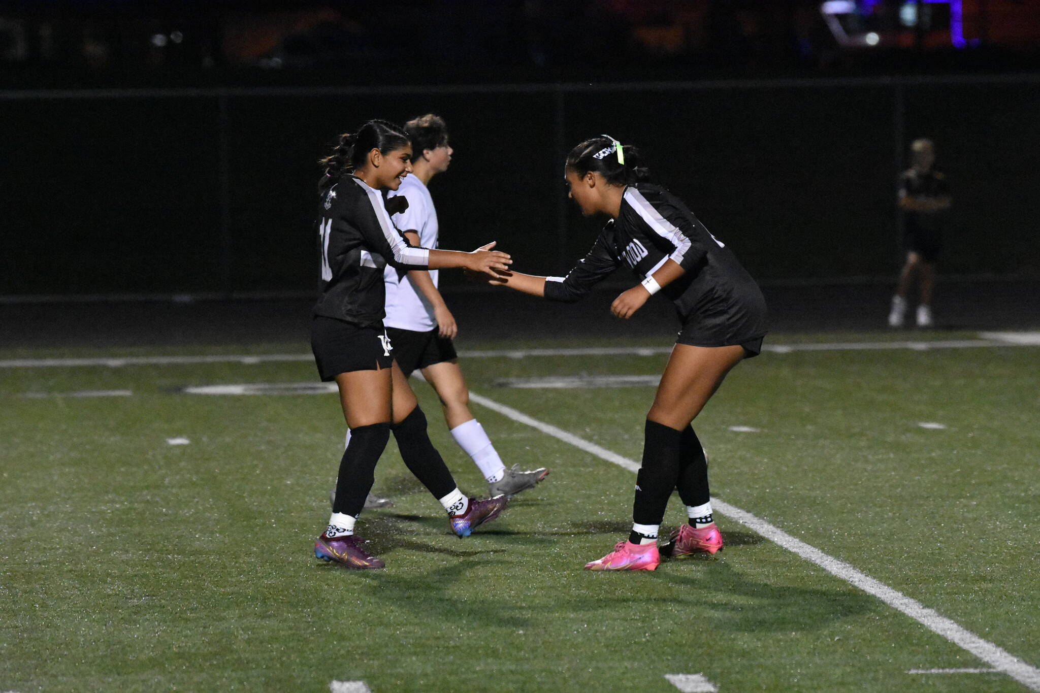 Kentwood’s Diya Thomas and Alyssa Cromwell celebrate a goal with a handshake. Ben Ray / The Reporter