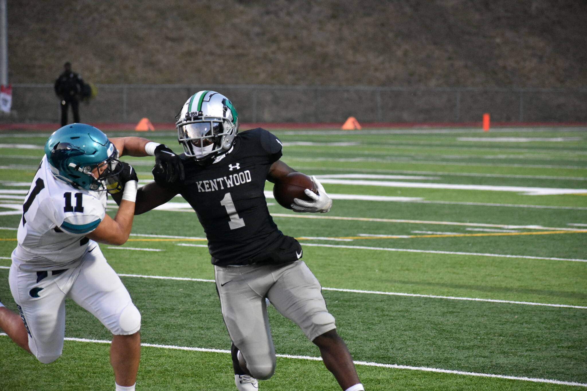 Kentwood’s Antoine Lee stiff-arms a Raven defender. Ben Ray / The Reporter