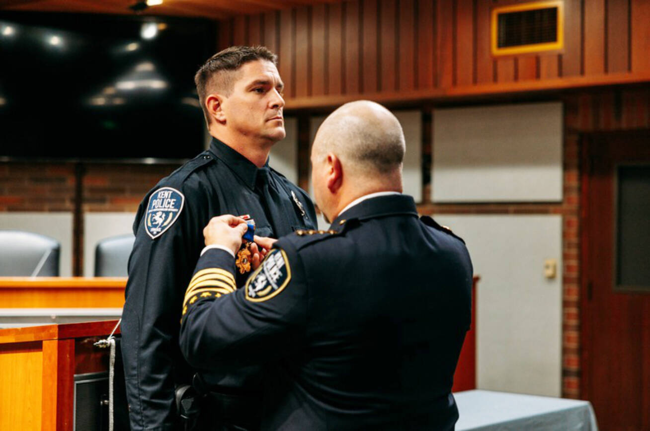 Kent Police Chief Rafael Padilla gives Officer Taylor Burns the Kent Police Department Medal of Honor for his heroic efforts during the rescue of a seaplane pilot in Lake Meridian. COURTESY PHOTO, Kent Police