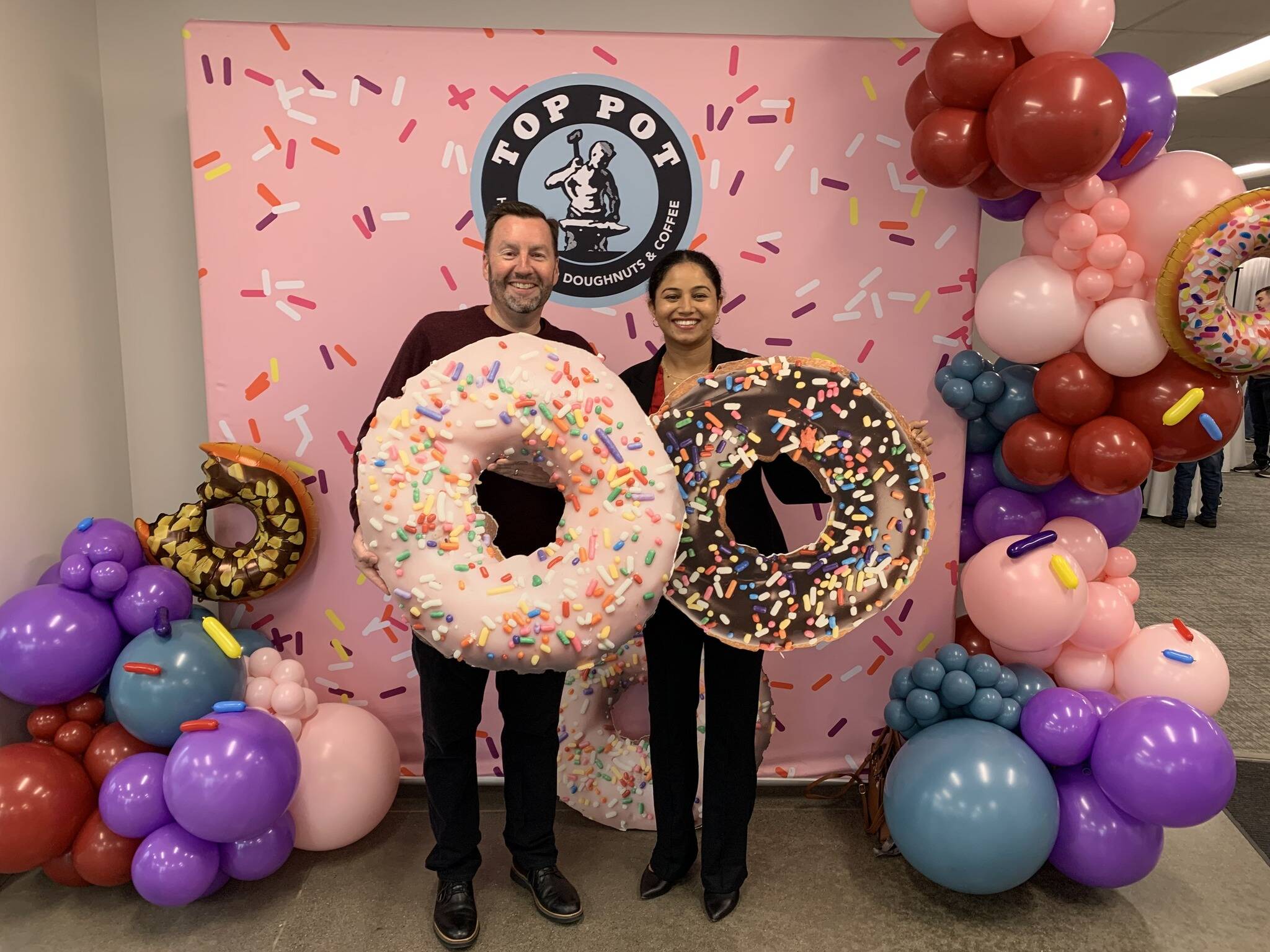 Top Pot Doughnuts CEO Jim Eschweiler, left, and Kent City Council President Satwinder Kaur celebrate Oct. 12 the opening of the company’s new production facility. COURTESY PHOTO, City of Kent