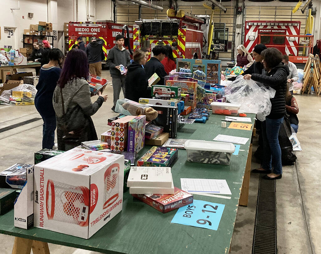 Volunteers prepare to sort and wrap gifts during the 2023 Toys for Joy program. COURTESY FILE PHOTO, Puget Sound Fire