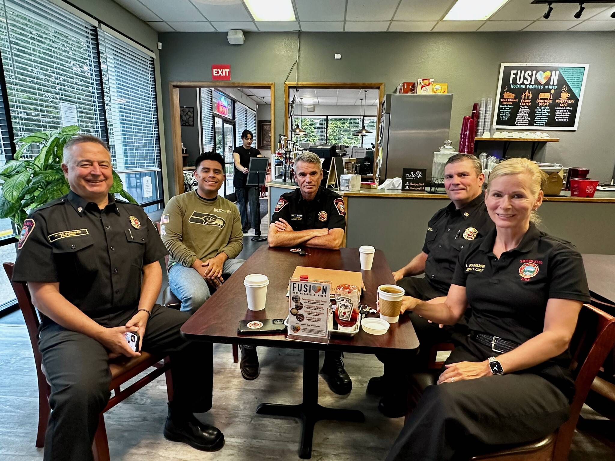 South King Fire Chief Dave Van Valkenburg, left, sits with a guest, District Chief Layne Winter, Deputy Chief Shane Smith and Deputy Chief Lisa Defenbaugh at Poverty Bay Cafe. FILE PHOTO, Joshua Solorzano/Sound Publishing