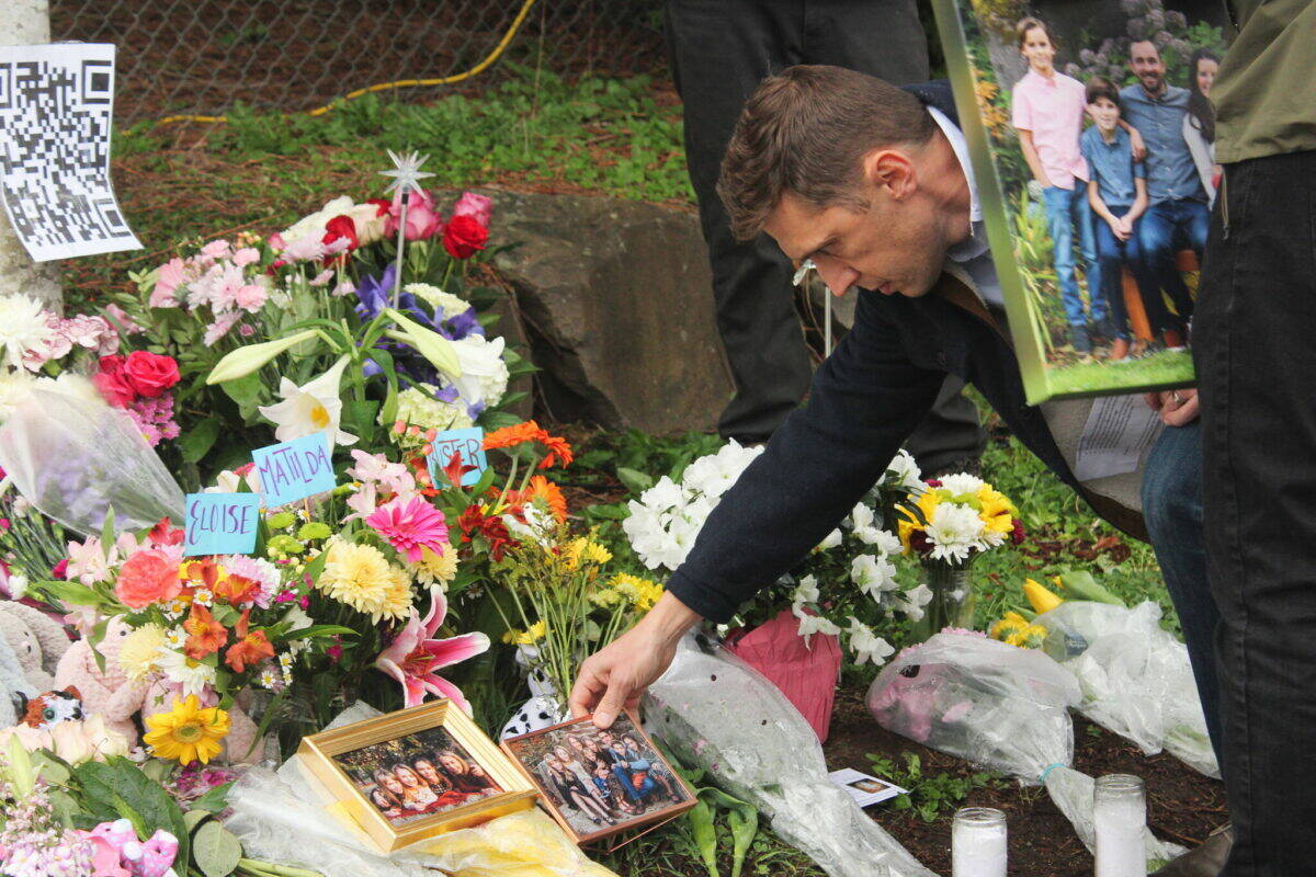 FILE PHOTO, Bailey Jo Josie, Sound Publishing
Chase Wilcoxson, father to Matilda, 13, and Eloise,12, places a family photo at the roadside memorial dedicated to his daughters, Buster Brown, 12, and Andrea Hudson, 38, killed in a March 19 crash.